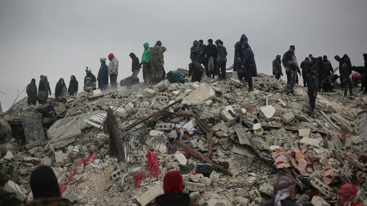 Survivors and rescuers search through rubble after a disaster in Idlib, Syria.