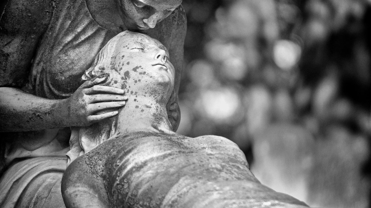 Black and white photo of a cemetery sculpture portraying deep emotion and spirituality.