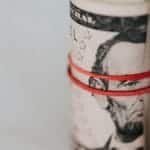 Close-up of a roll of US dollars wrapped with a red rubber band focusing on financial abundance.