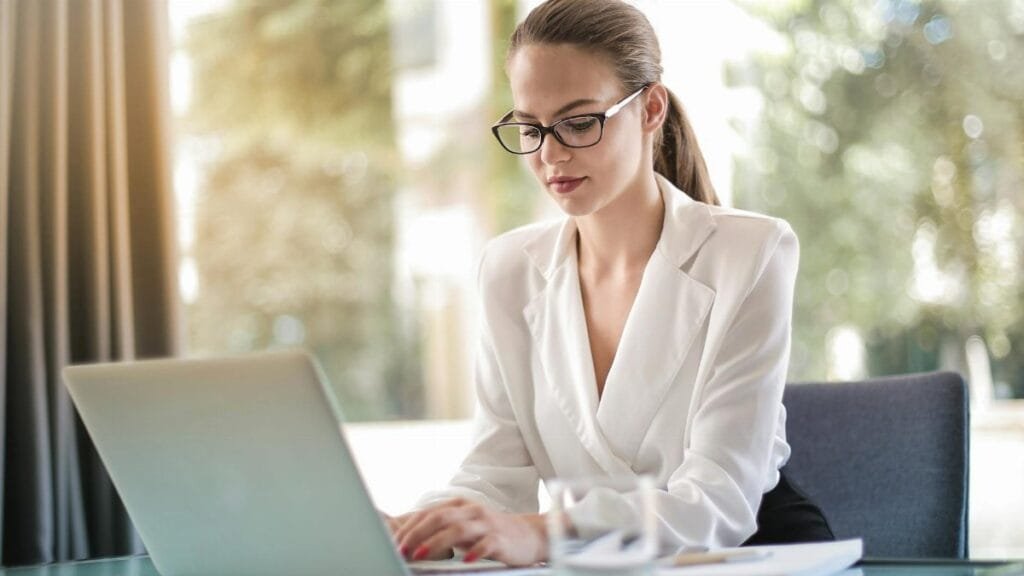 Confident businesswoman using a laptop at her desk, focused on her work.