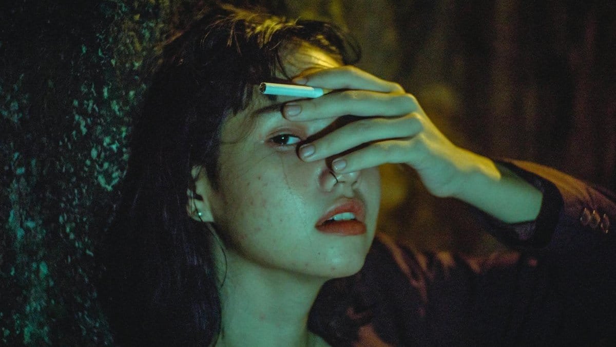 Dramatic portrait of a woman in low light, expressing emotion and contemplation.
