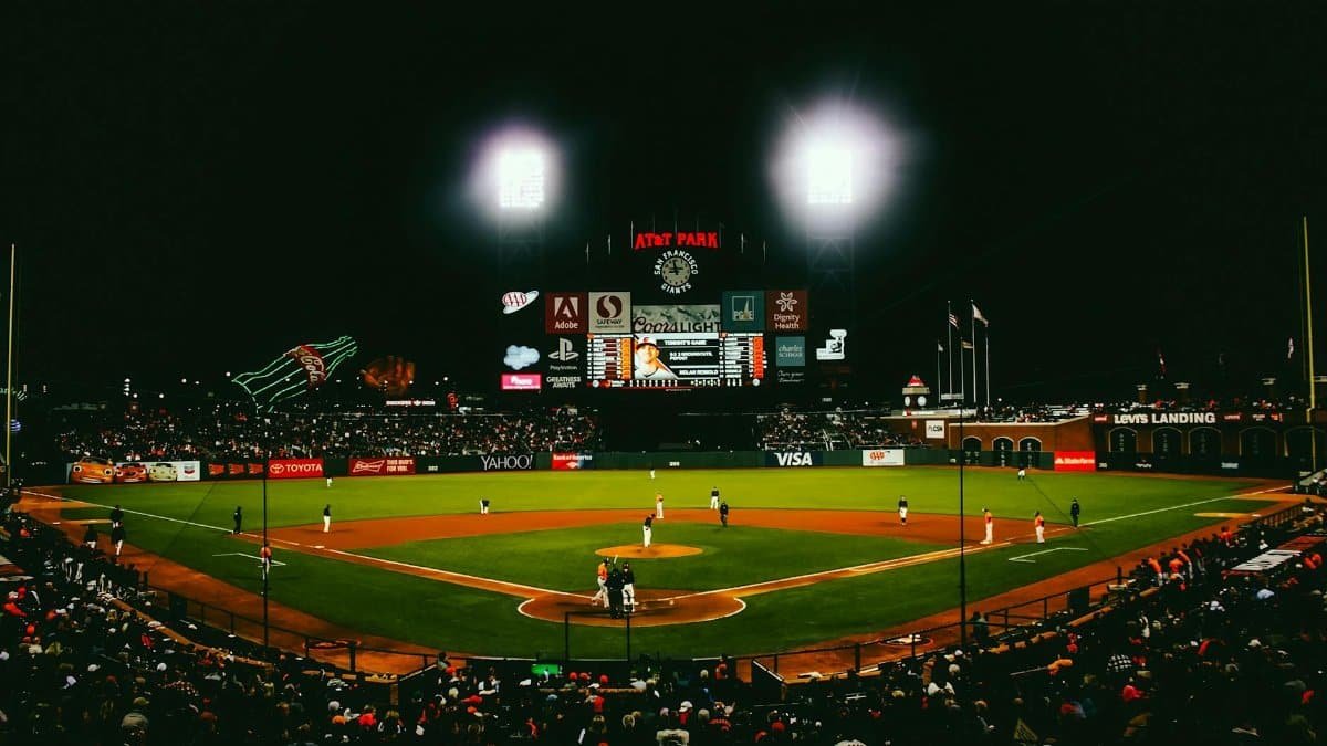 Exciting evening baseball game with fans at AT&T Park stadium under bright lights.