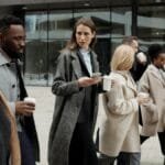 A group of diverse business professionals enjoying a coffee break outdoors in the city.