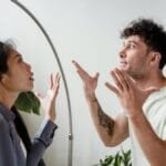 A couple argues indoors amidst greenery, showcasing emotions and interpersonal conflict.