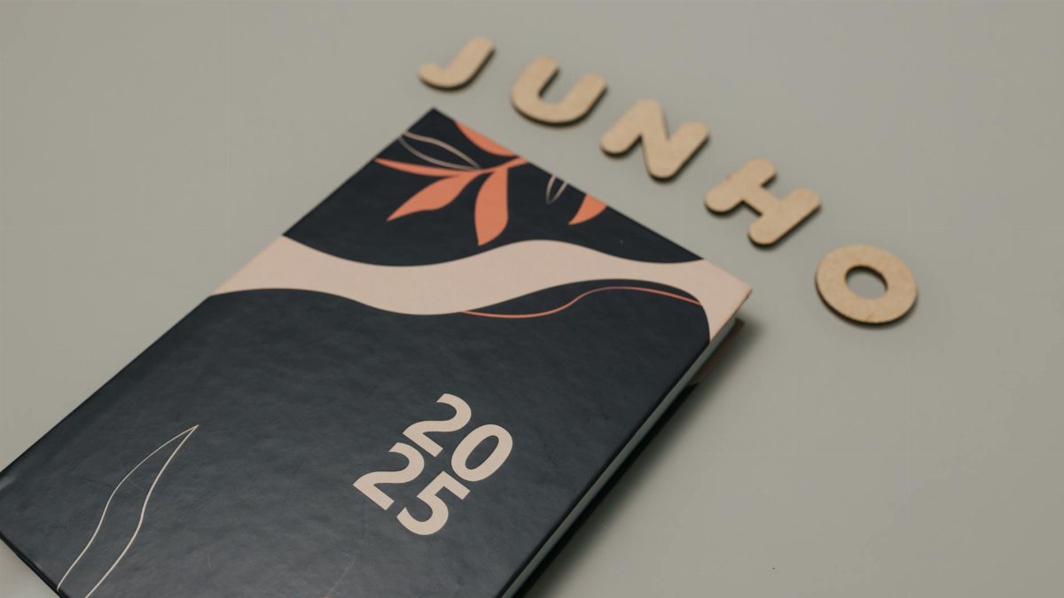 A sleek 2025 planner with a modern design sits beneath cutout letters spelling 'Junho'. Perfect for organizing and planning.