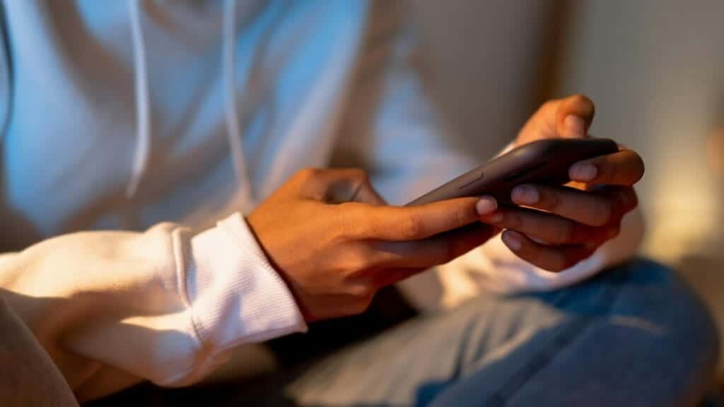 Close-up of a person holding a smartphone indoors, emphasizing digital interaction.