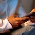 Close-up of a person holding a smartphone indoors, emphasizing digital interaction.