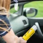 Police officer administering a breathalyzer test to a driver in a car, ensuring road safety.