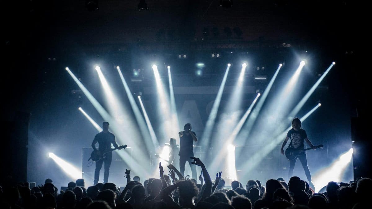 Energetic live concert with musicians performing on stage, engaging the crowd with vibrant lighting effects.