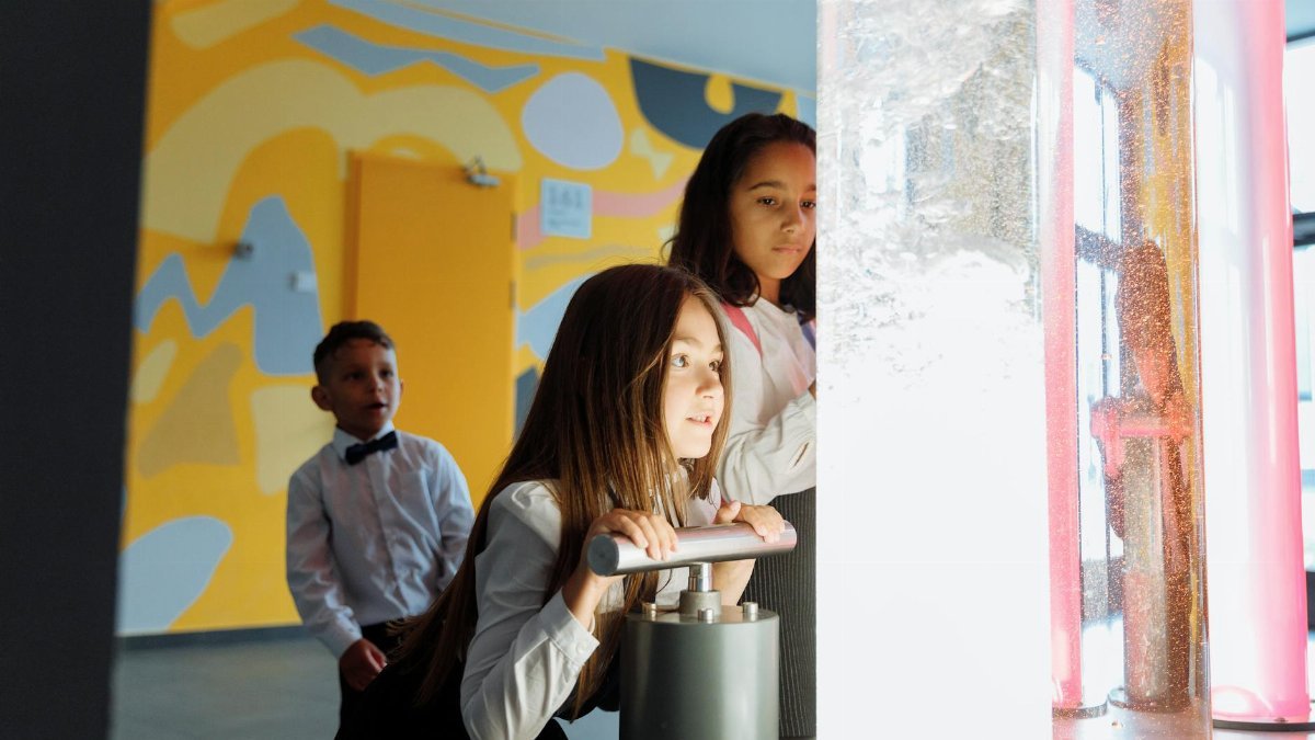 Children engage in a science experiment with colored liquids at school.