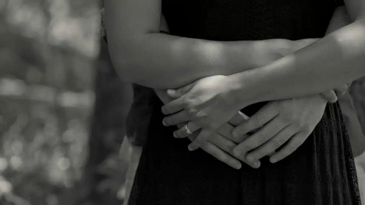 Close-up black and white photo of a couple hugging outdoors, capturing intimacy and love.