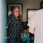 A volunteer visits an elderly person at home, creating a warm connection.