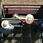 High angle view of cowboys in checkered shirts and hats managing sheep in Hailey, Idaho.