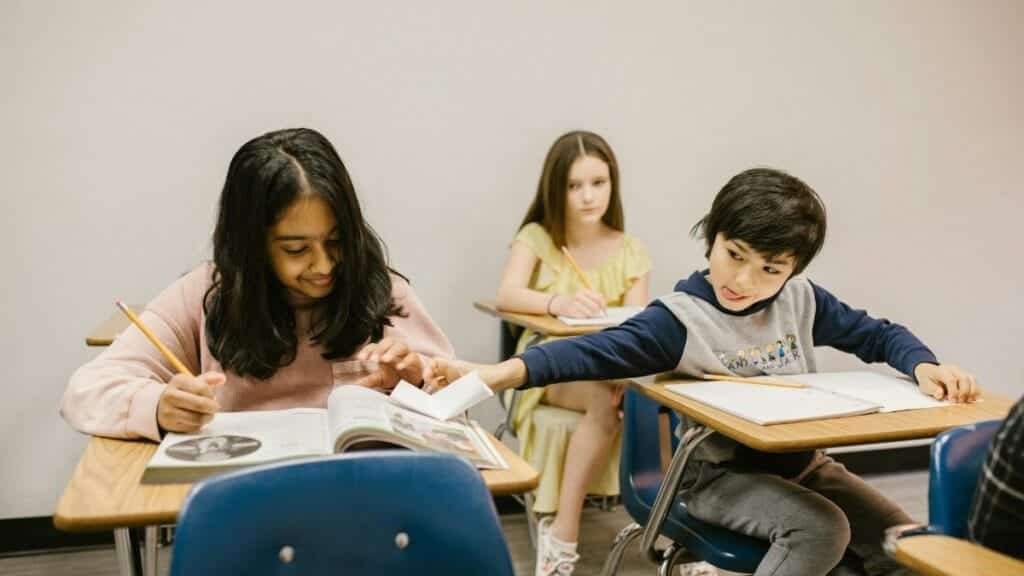 Group of diverse students in a classroom displaying typical school interactions.