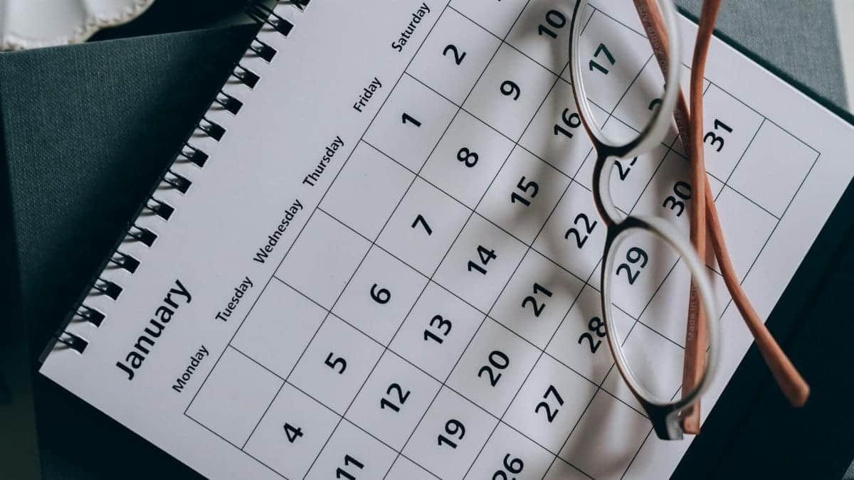 A close-up of a January calendar with eyeglasses on a table, emphasizing planning and organization.