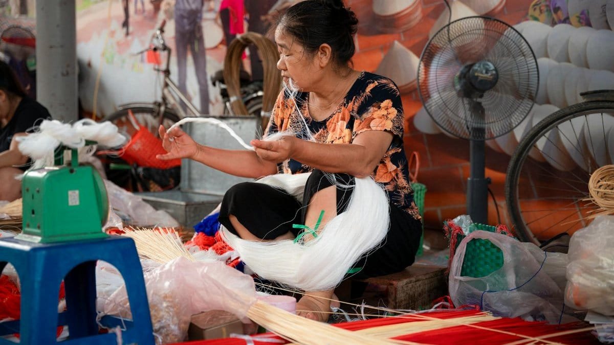 Woman weaving traditional items in a local workshop in Hà Nội, Việt Nam.