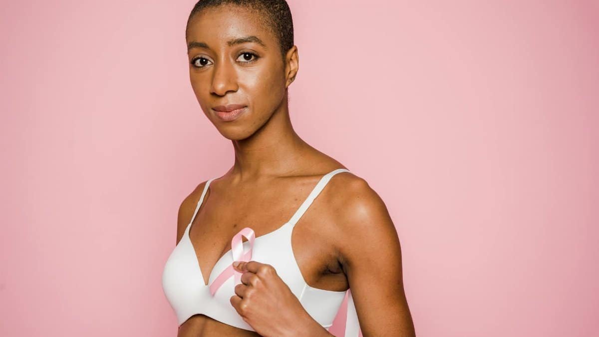 Empowering portrait of a woman with a pink breast cancer ribbon symbolizing awareness.