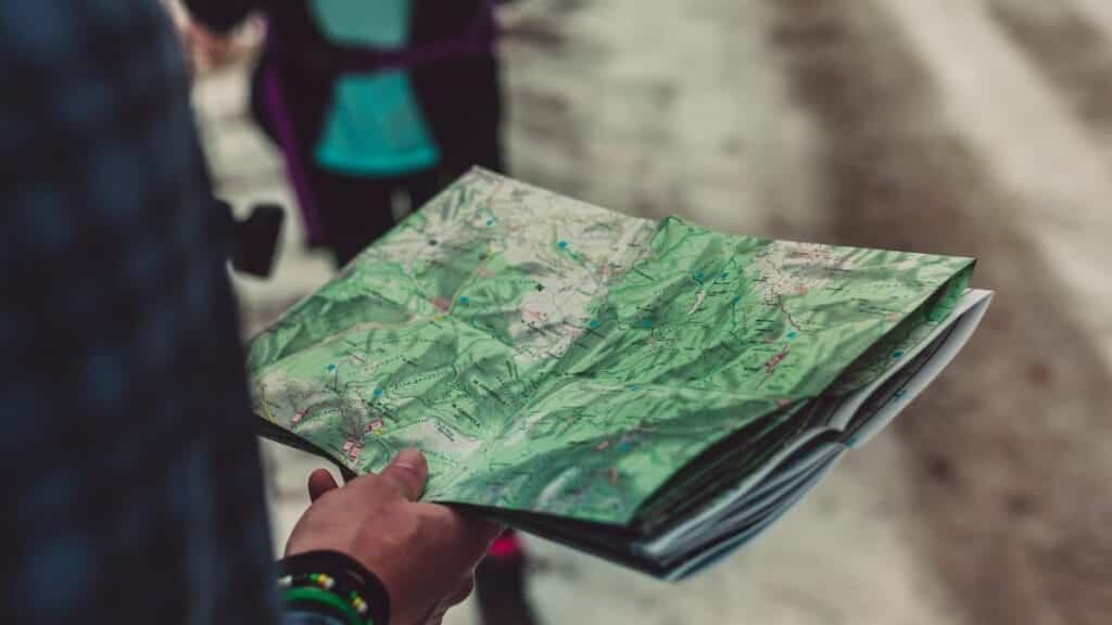 A close-up of a person holding a detailed route map outdoors, ideal for travel and exploration themes.