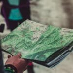 A close-up of a person holding a detailed route map outdoors, ideal for travel and exploration themes.