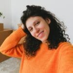 Cheerful woman moving into new apartment, surrounded by boxes.
