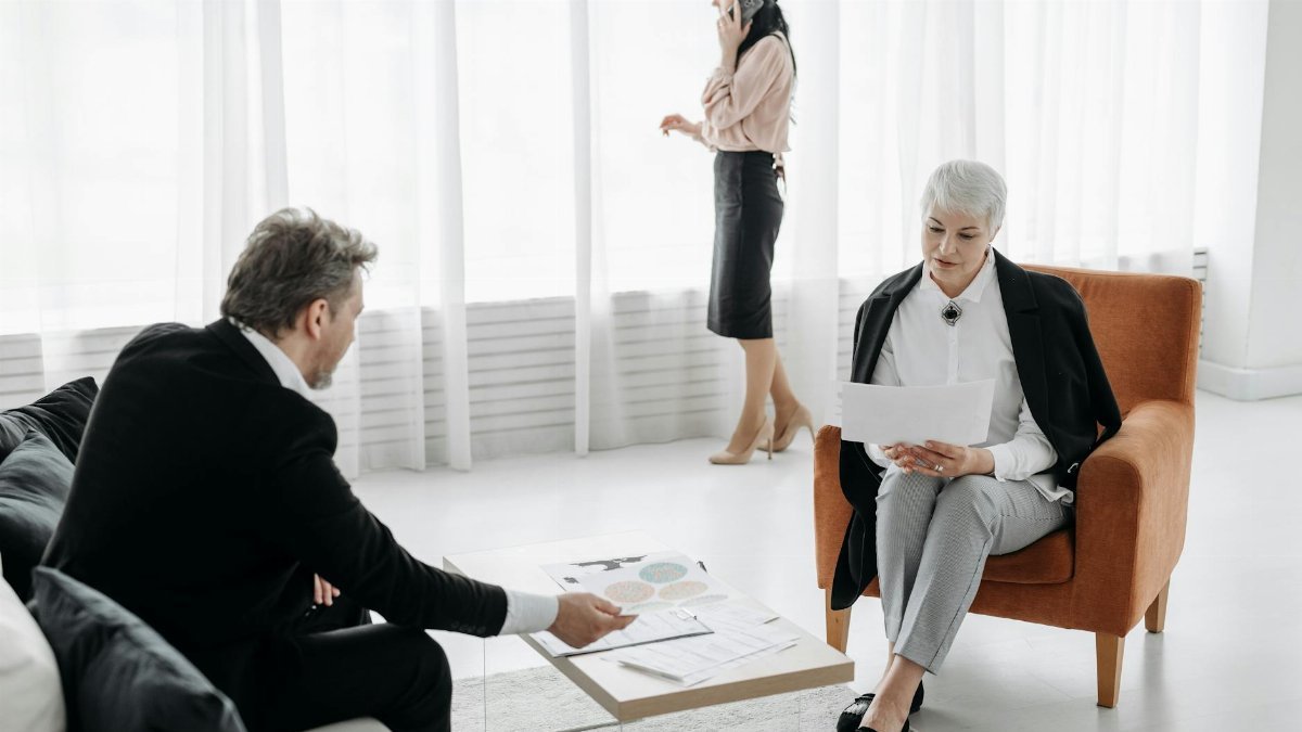 Business professionals engaged in a discussion in a modern office setting with documents.