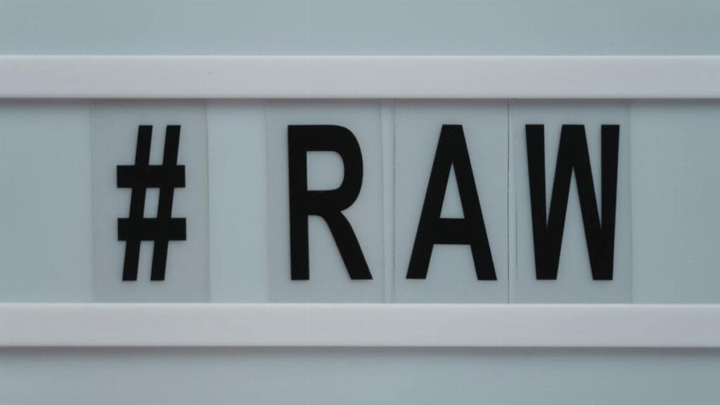 Close-up of a lightbox displaying the hashtag RAW on a white background.