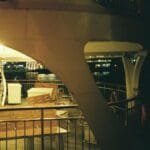 Empty ferry deck at night with city lights reflecting over water.