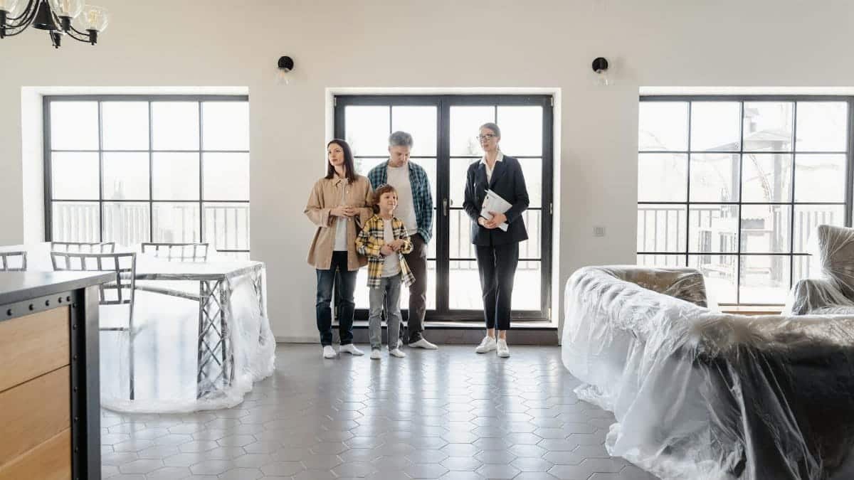 Family explores new home with agent, highlighting modern interiors.