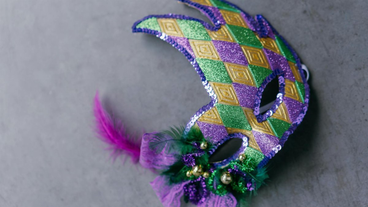 Closeup of a colorful Mardi Gras mask with vibrant purple, green, and gold decorations