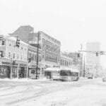 Snow-covered urban street scene in Cambridge, Massachusetts during winter snowfall.