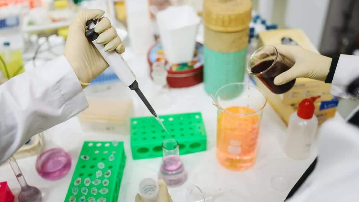 Scientists conducting an experiment with chemicals and tools in a modern lab setting.