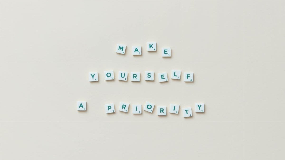 Top view of motivational phrase 'Make Yourself a Priority' with Scrabble tiles on white background.