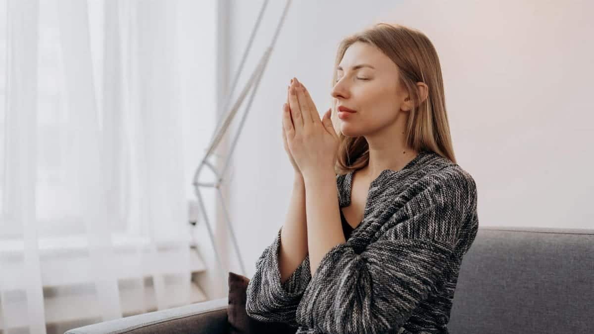 A woman meditates peacefully indoors, seeking relaxation and inner peace through mindful practices.