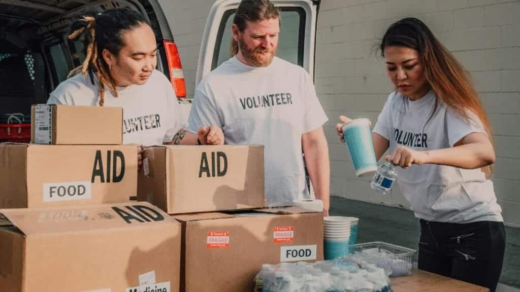 Volunteers sort aid and food boxes for a charity drive, promoting togetherness and social good.