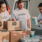 Volunteers sort aid and food boxes for a charity drive, promoting togetherness and social good.