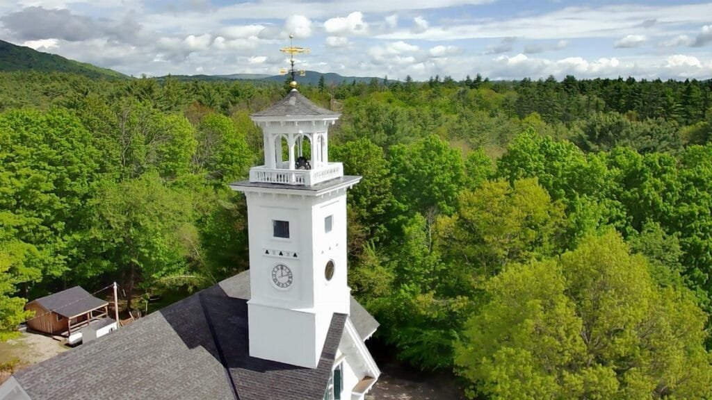 Aerial view of the historic town hall tower amidst green trees in Effingham, New Hampshire.