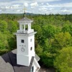 Aerial view of the historic town hall tower amidst green trees in Effingham, New Hampshire.