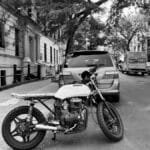 Black and white photo of a motorcycle on a quiet New York City street.
