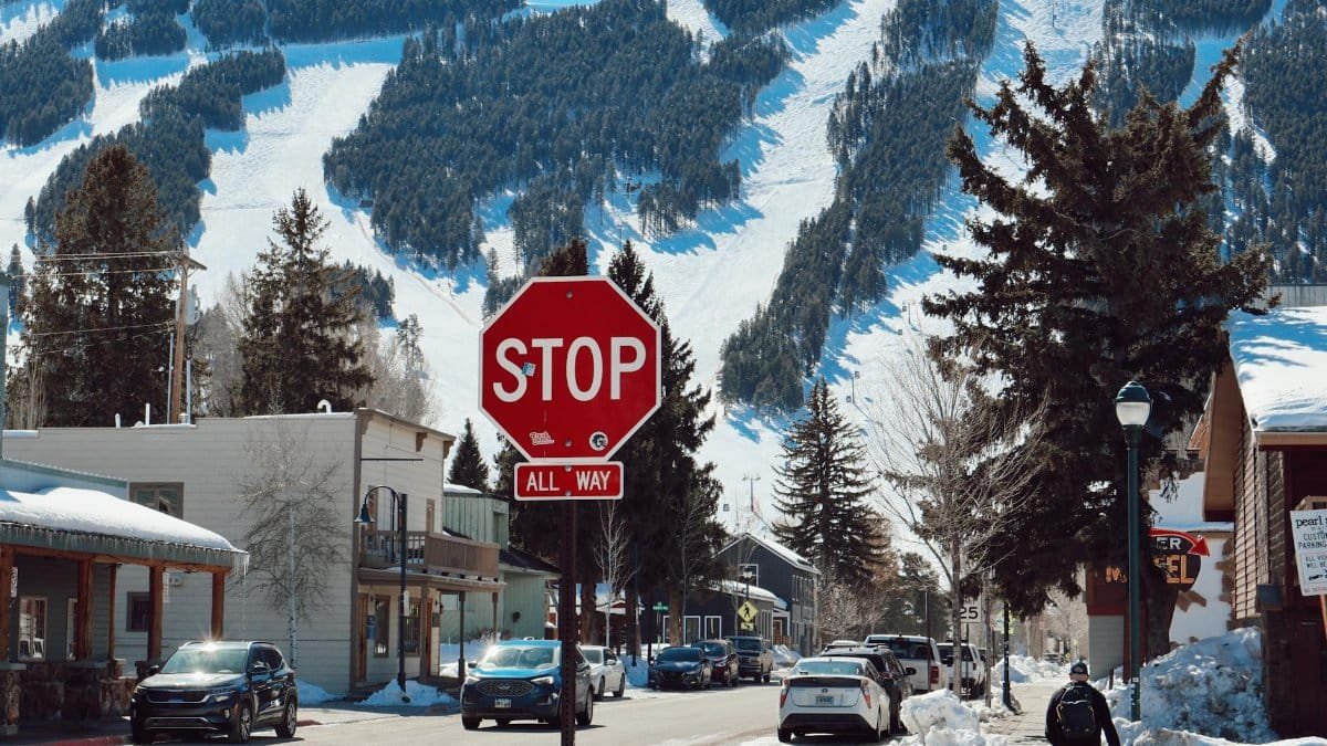 Scenic winter street view in Jackson, Wyoming, featuring snow and mountain backdrop.
