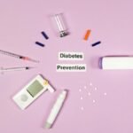 A flat lay of diabetes prevention supplies including a glucometer, insulin pen, and syringes on a pink background.