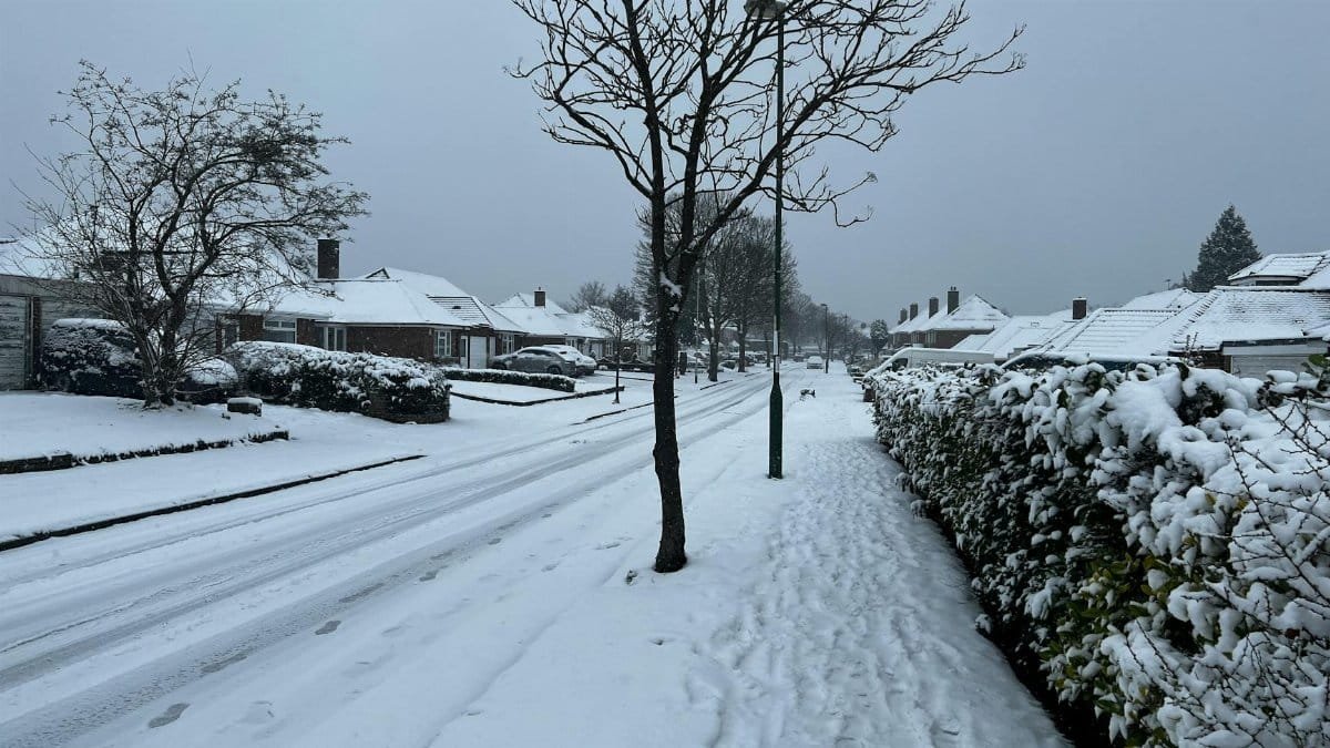 A serene winter scene of a snow-covered suburban street in Birmingham, England.