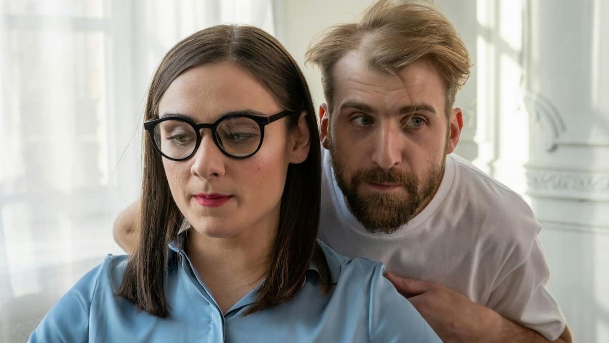 A man and woman engaged in a thoughtful discussion indoors, showcasing emotions.