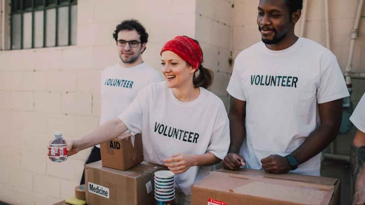 Volunteers distributing aid at an outdoor donation center, promoting social impact and diversity.