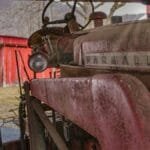 Vintage Farmall 460 tractor parked in an old barn with red wooden walls in rural Pennsylvania.