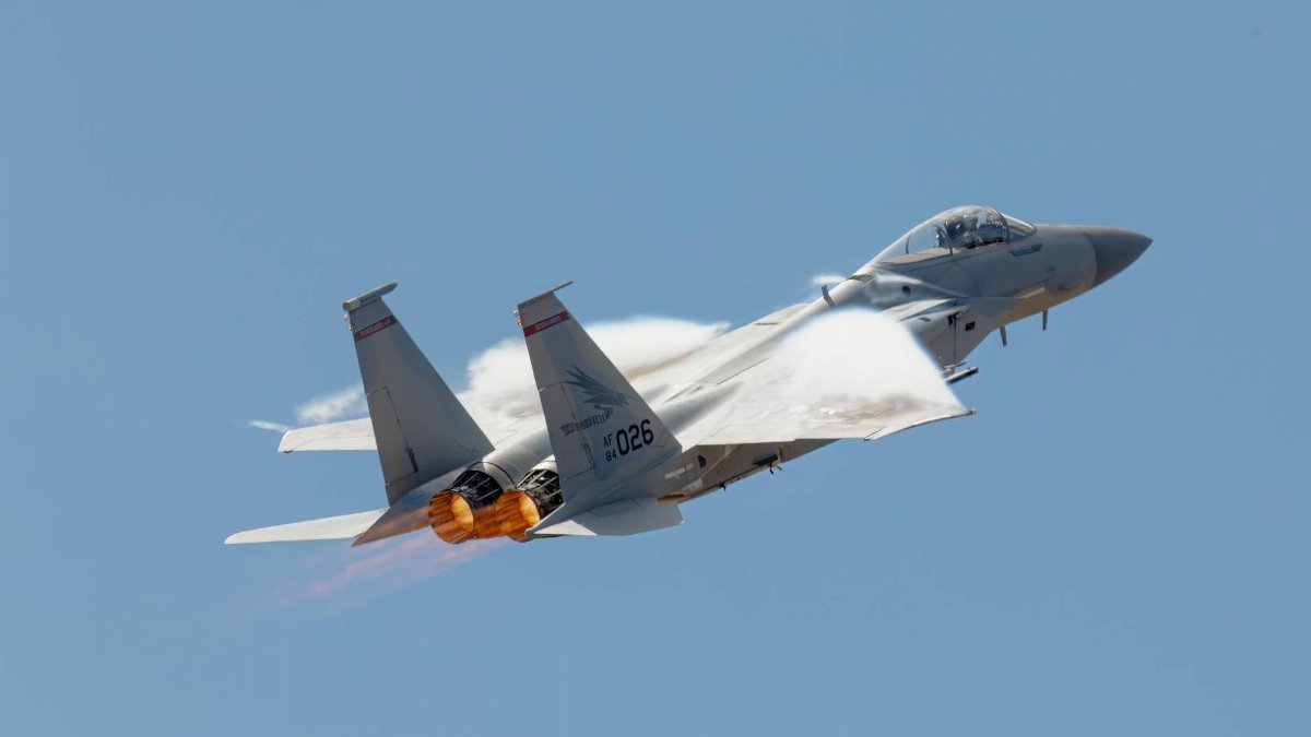 High-speed F-15 jet soaring in clear sky, showcasing its power and agility.