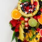 Colorful flat lay of assorted tropical fruits including pineapple, berries, and citrus.
