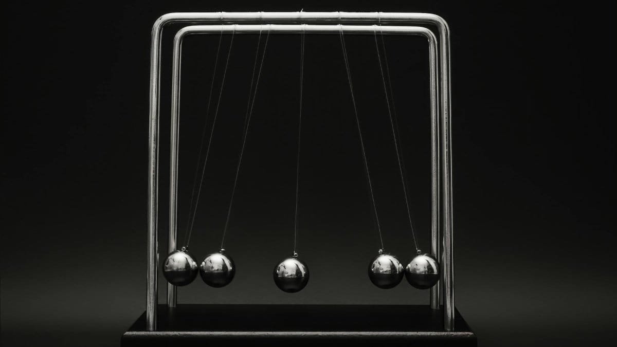 Newton's cradle for physics principles and motion study on a dark background.