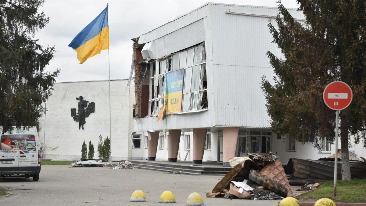 A damaged building with a Ukraine flag depicts the impact of war in an urban area.