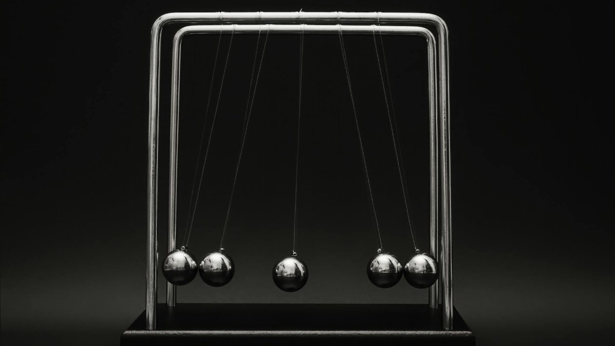 Newton's cradle for physics principles and motion study on a dark background.