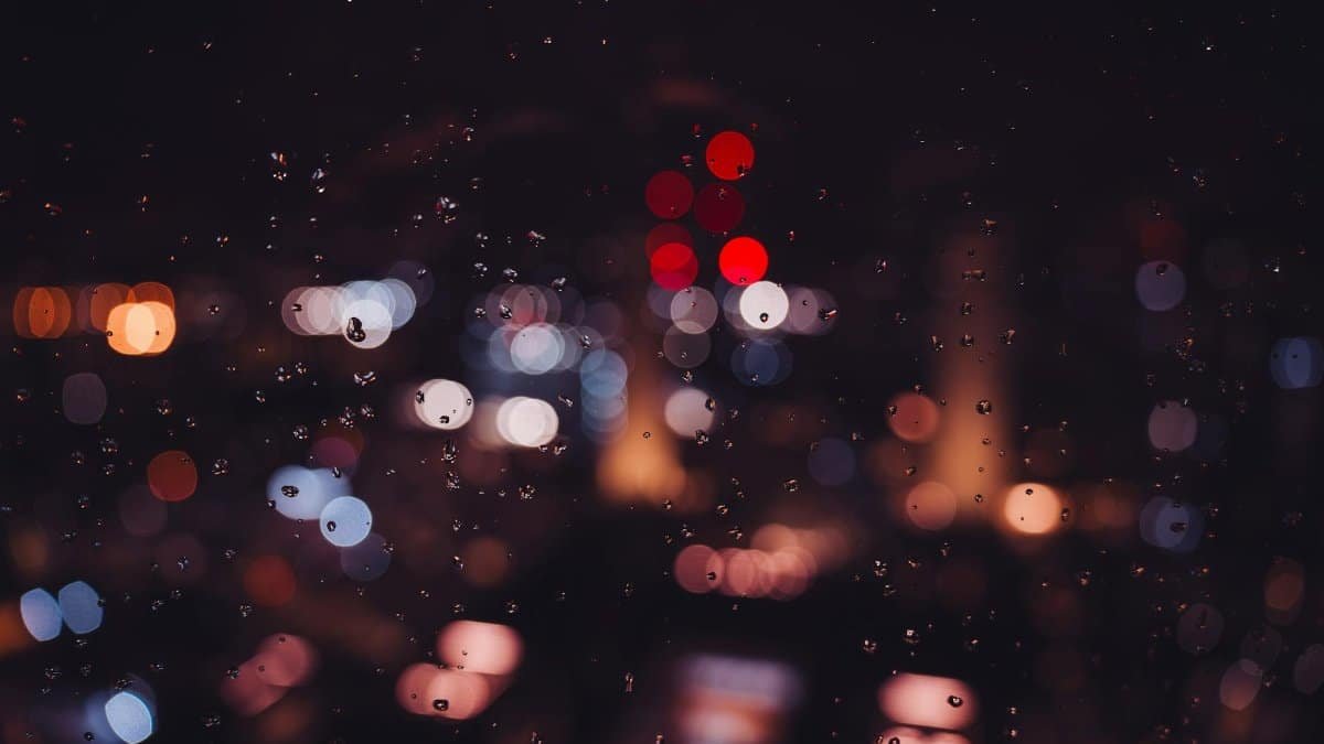 Bokeh city lights and raindrops on glass create a magical nighttime ambiance in London.
